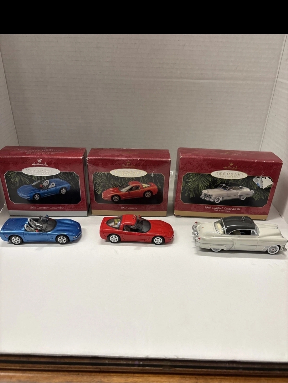 Three hallmark keepsake ornaments two Corvettes and one Cadillac
